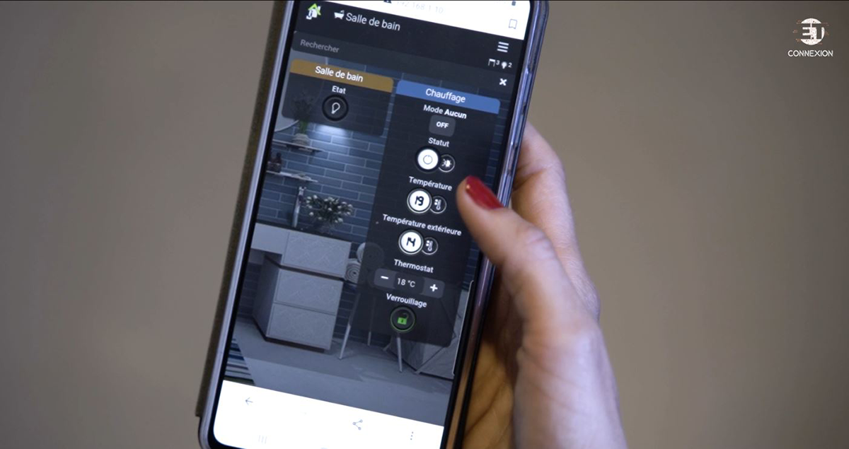 main de femme tenant un smartphone pour contrôler son logement connecté