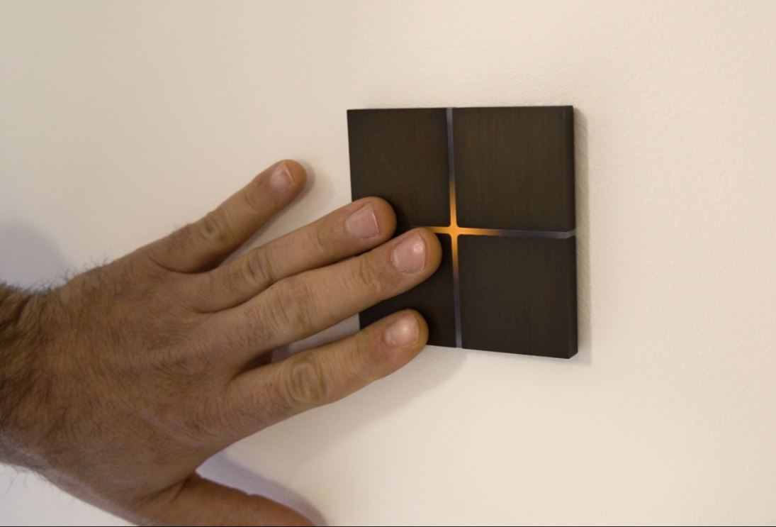 main d'homme appuyant sur un interrupteur composé de 4 carrés en bois