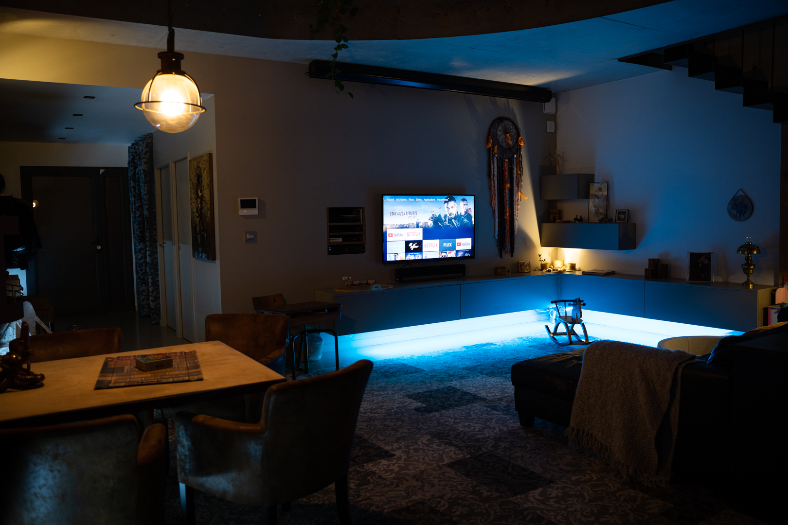 ambiance d'éclairage d'un salon de couleur bleu avec télévision allumée