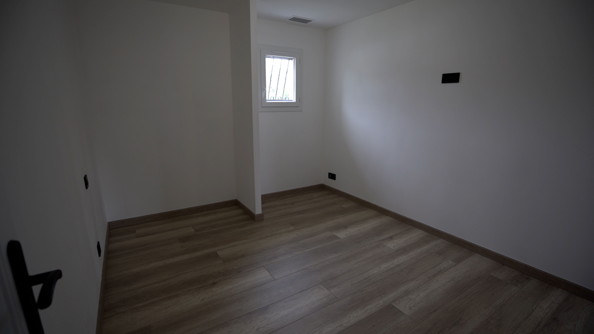 chambre vide avec parquet, mur et plafond de couleur blanc