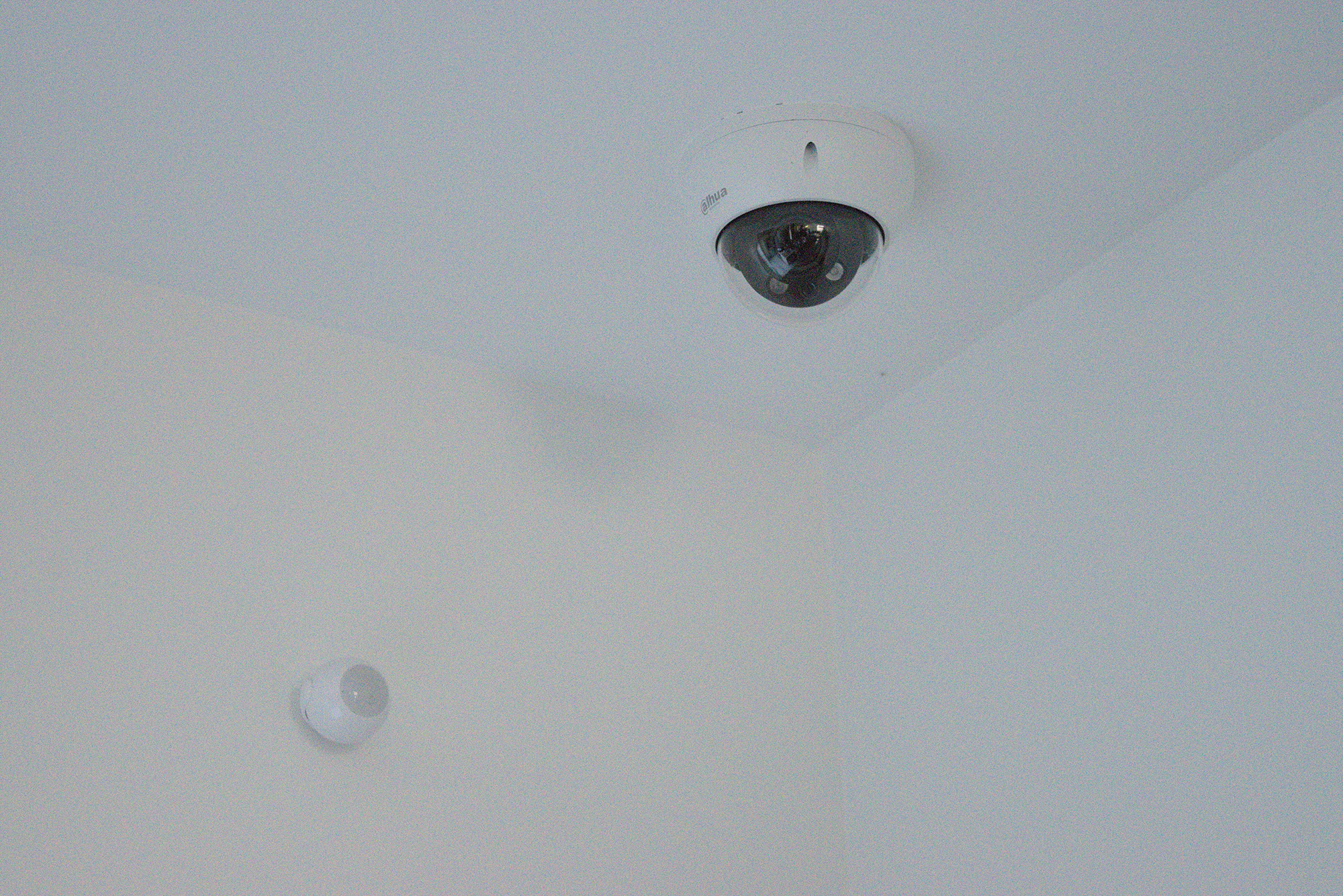 Caméra de surveillance intérieur placée sur un plafond blanc